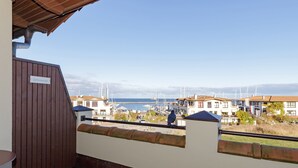 A balcony with a view of a marina and buildings.