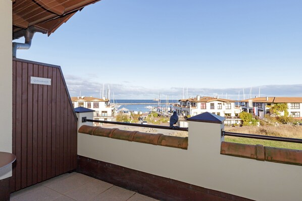Un balcón con vistas a un puerto deportivo y edificios.