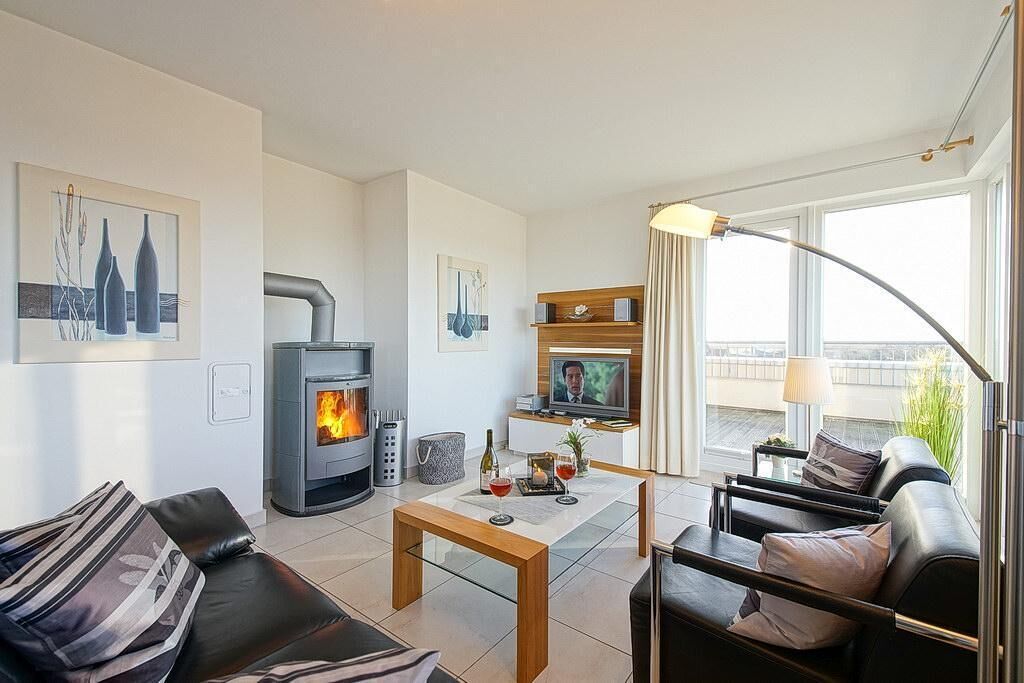 Ein modernes Wohnzimmer mit Kamin, Fernseher und Balkon mit Aussicht.