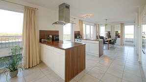 Una cocina moderna con una isla central, estufa integrada y un amplio ventanal con vistas.