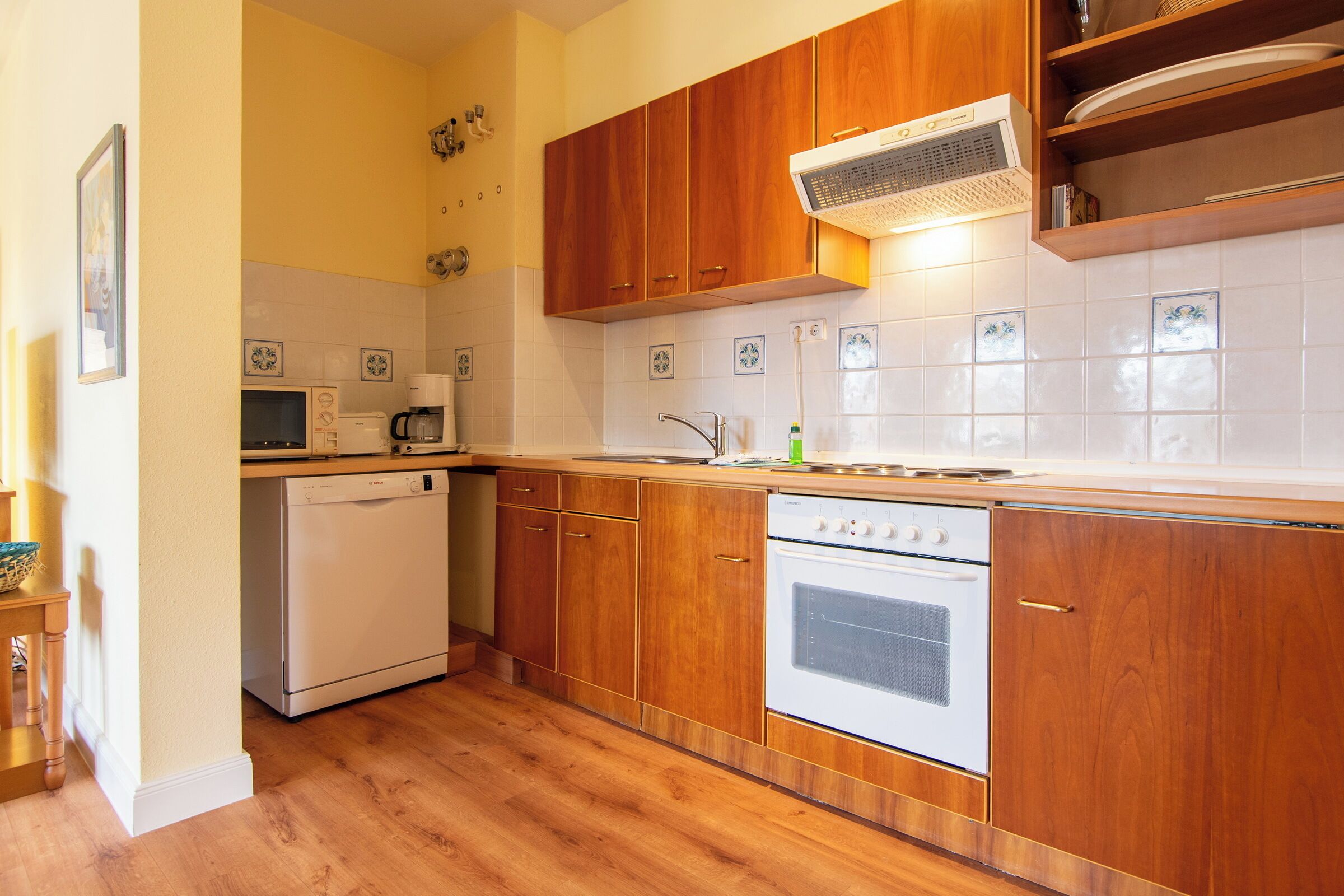 A kitchen with wooden cabinets, a dishwasher, a microwave, and a stove.