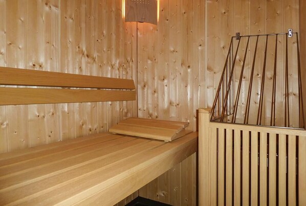 Un sauna en bois, doté de bancs et d’un porte-serviettes.