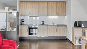 Una cocina moderna con armarios de madera, electrodomésticos de acero inoxidable y un horno empotrado.
