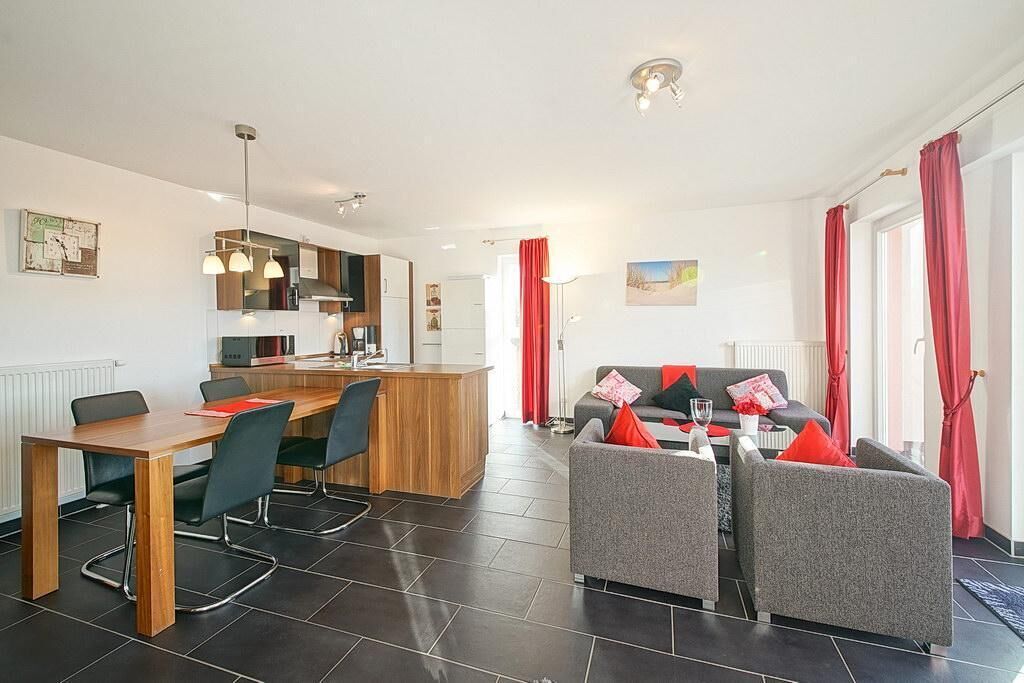 A modern living room with a dining area, a kitchen, and a sofa set.