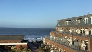 Un edificio costero con varios balcones, vista al mar y cielo despejado.