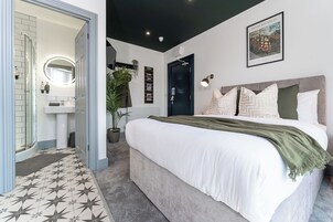 Un dormitorio moderno con una cama grande, una lámpara de noche y un cuadro en la pared.