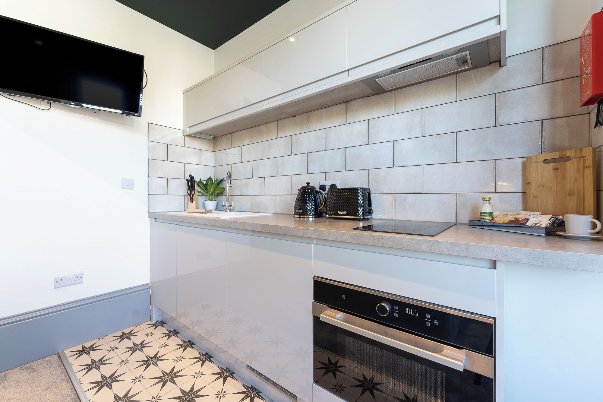 A modern kitchen with a built-in oven, a coffee maker, and a microwave.