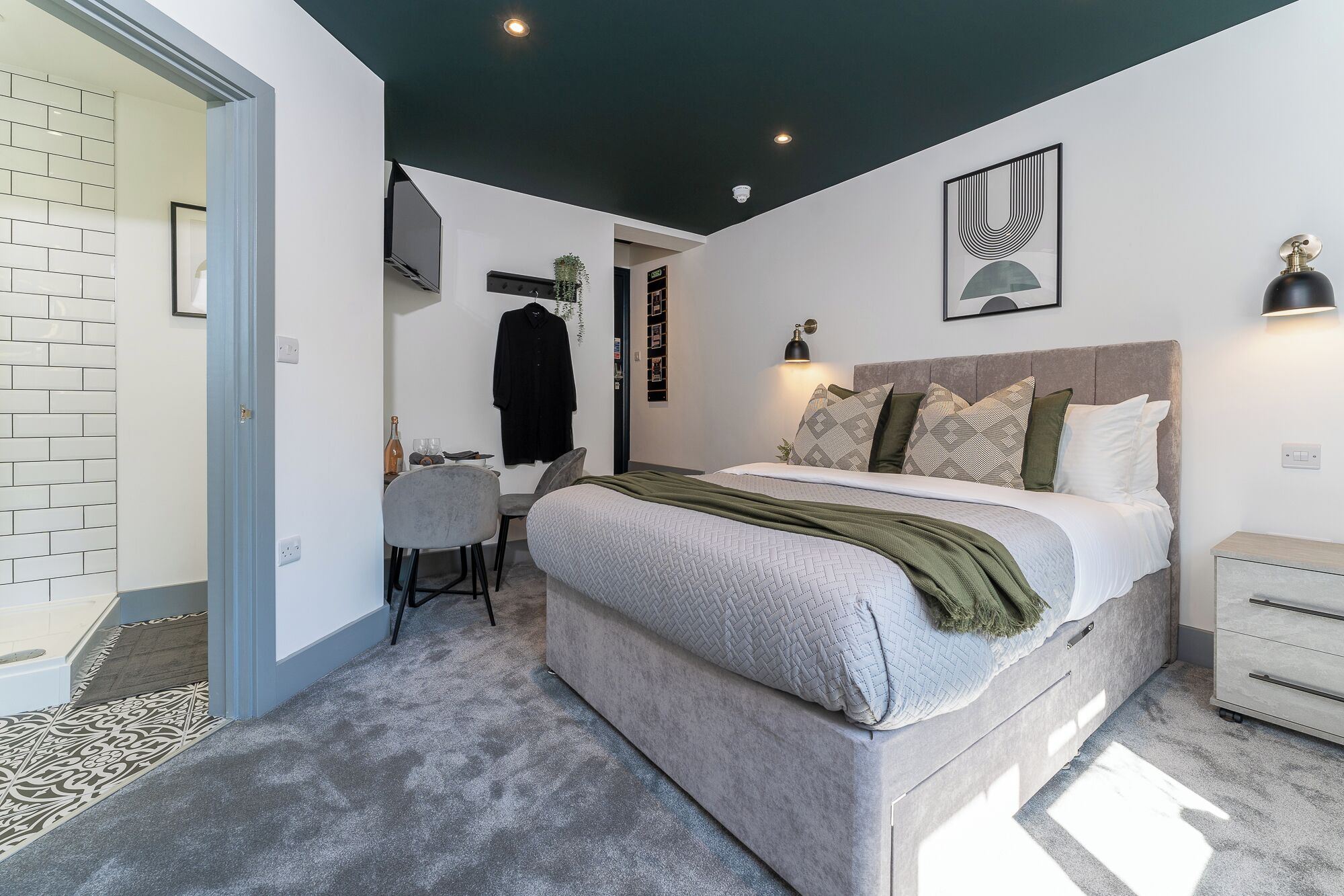 Une chambre moderne avec un lit, une table de chevet et un bureau avec une chaise.