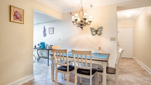 A dining area with a chandelier, a table with chairs, and a butterfly wall decoration. - Dolly Dreams - Fireplace, Minutes to Dollywood! (Pigeon Forge)