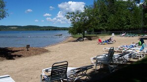 Une plage avec des chaises longues et vue sur le lac.