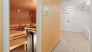 A sauna room with wooden benches and a wooden wall.