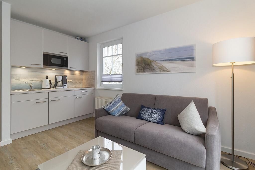 A modern living room with a grey sofa, a coffee table, and a floor lamp.