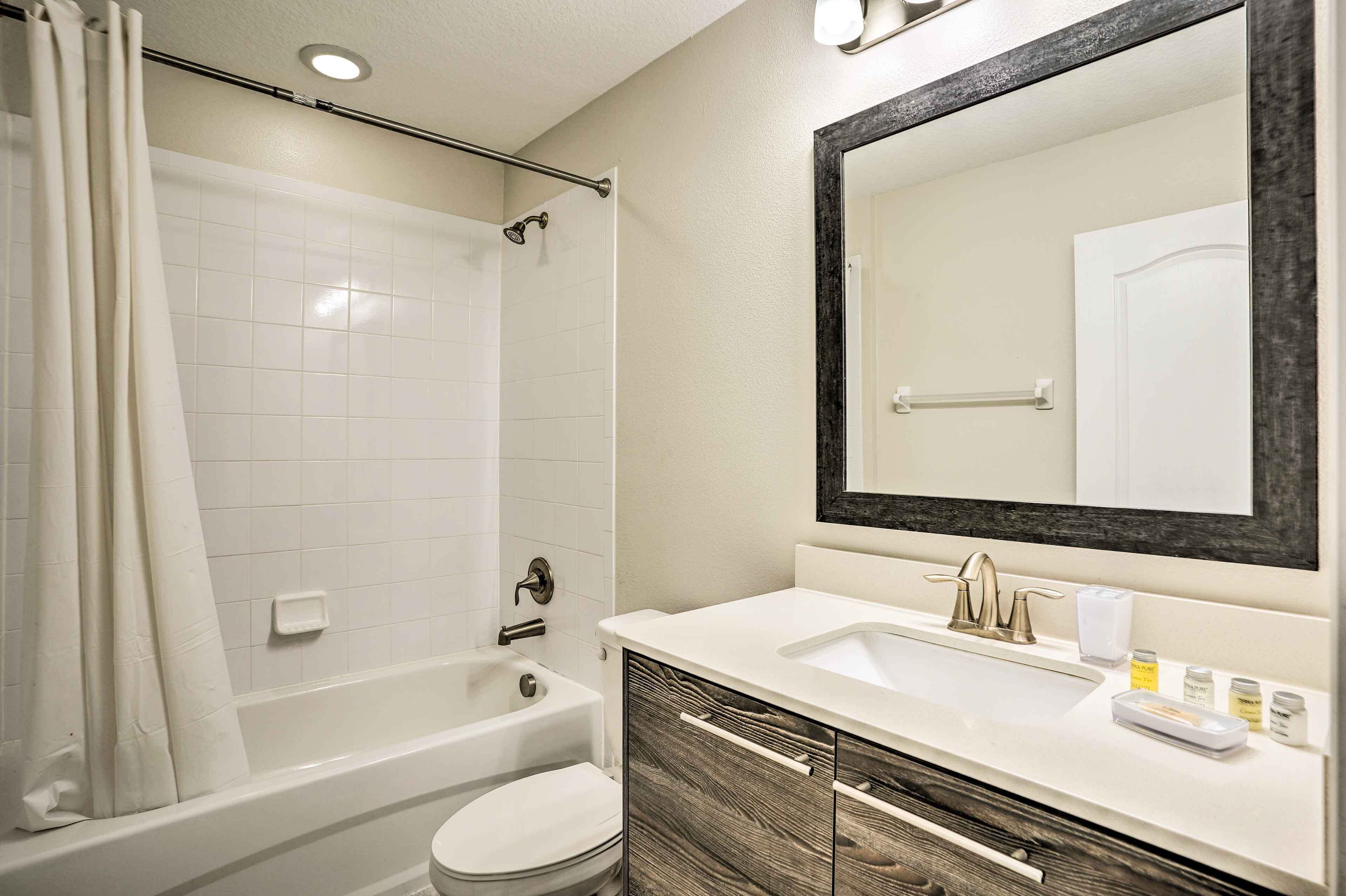 Une salle de bain moderne équipée d’une baignoire, de toilettes et d’un lavabo.
