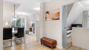 A modern interior with a dining area, a bench, and a large window.