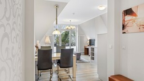 A modern interior with a dining area, a bench, and a view through a window.