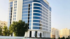 A modern hotel with a curved facade, multiple floors, and a prominent entrance with columns. - Zaha Taiba Hotel (Madinah)