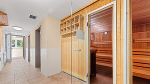 Un pasillo con taquillas de madera y una zona de sauna.