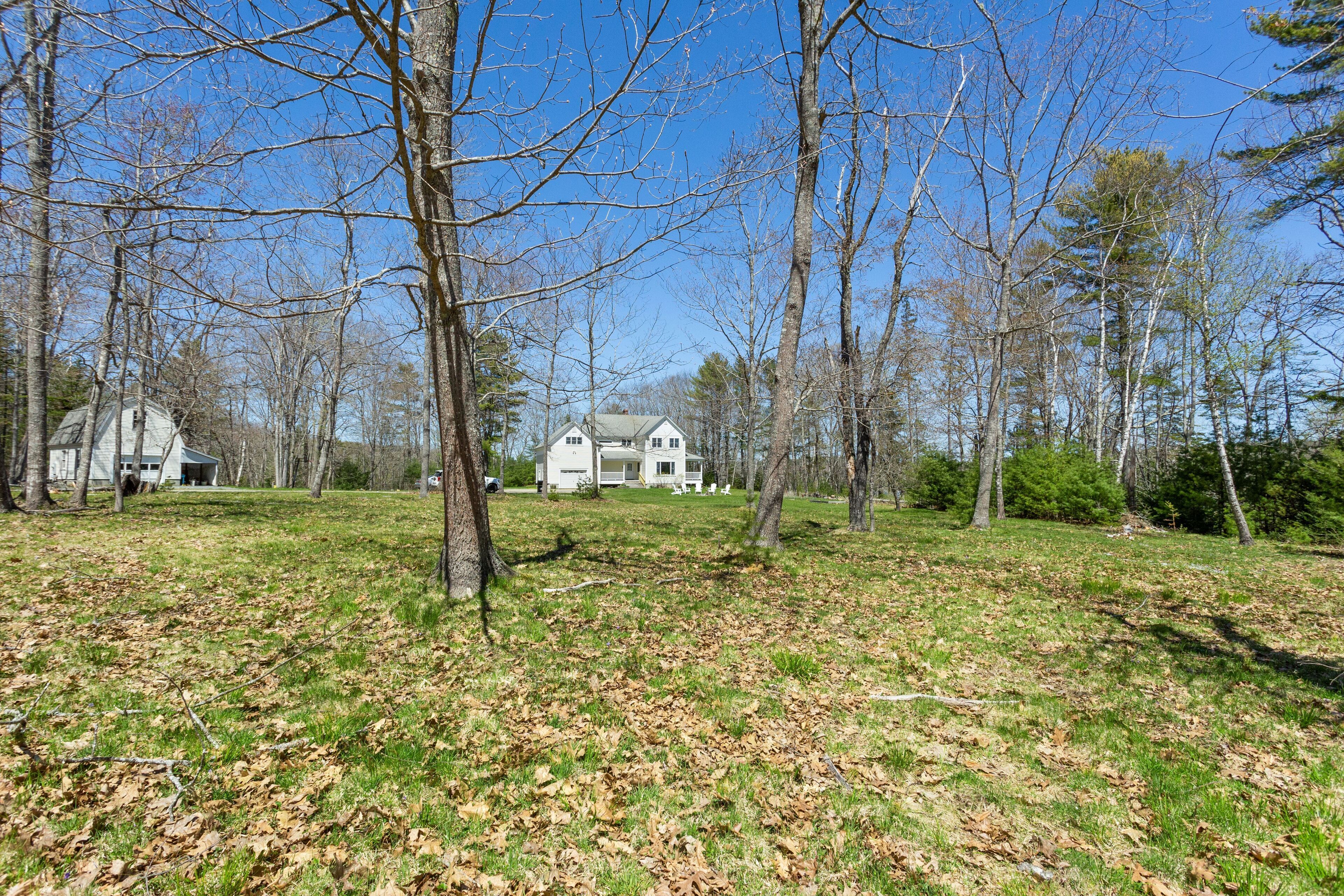 A large house surrounded by trees and a grassy yard.