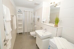 Un bagno moderno con doccia, WC e lavabo.