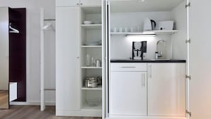 Una cocina moderna con armarios blancos, una encimera y una cafetera.