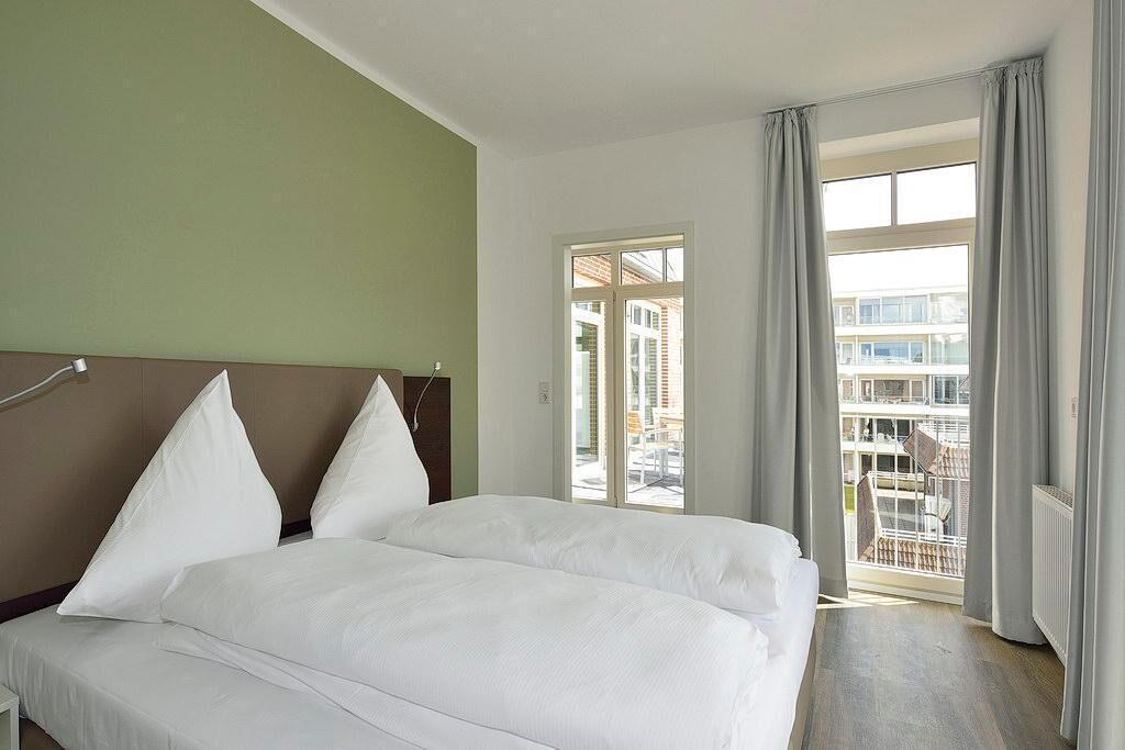 Une chambre d’hôtel avec un lit, une vue sur l’extérieur et une fenêtre avec des rideaux.