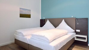 Un dormitorio moderno con una cama, una mesita de noche y una lámpara de pared.