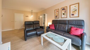 A modern living room with two leather sofas, a white coffee table, and a lamp.