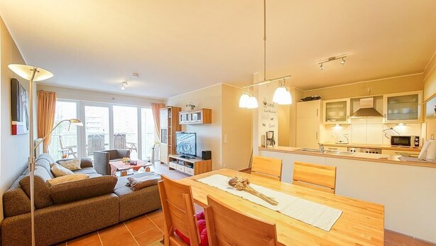 A compact living space with a sofa, dining table, and kitchenette.