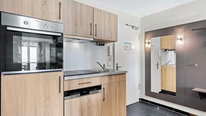 A modern kitchen with wooden cabinets, a stainless steel oven, and a built-in sink.