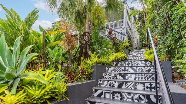 A staircase with black and white patterned steps surrounded by lush greenery. - Contemporary Studio in the heart of Paddington (Paddington)
