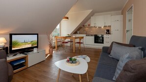 A modern apartment with a living room, dining area, and kitchen. - Ruhige, Hübsche Ferienwohnung in Strandnähe mit Balkon am Idyllischen Stadtwald (Ostseebad Kühlungsborn)