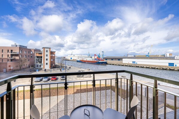 Vista desde un balcón sobre un río con un barco grande en el puerto.