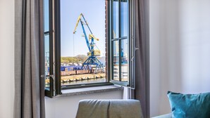 Una habitación con un ventanal grande que da a una zona de construcción con grúas.