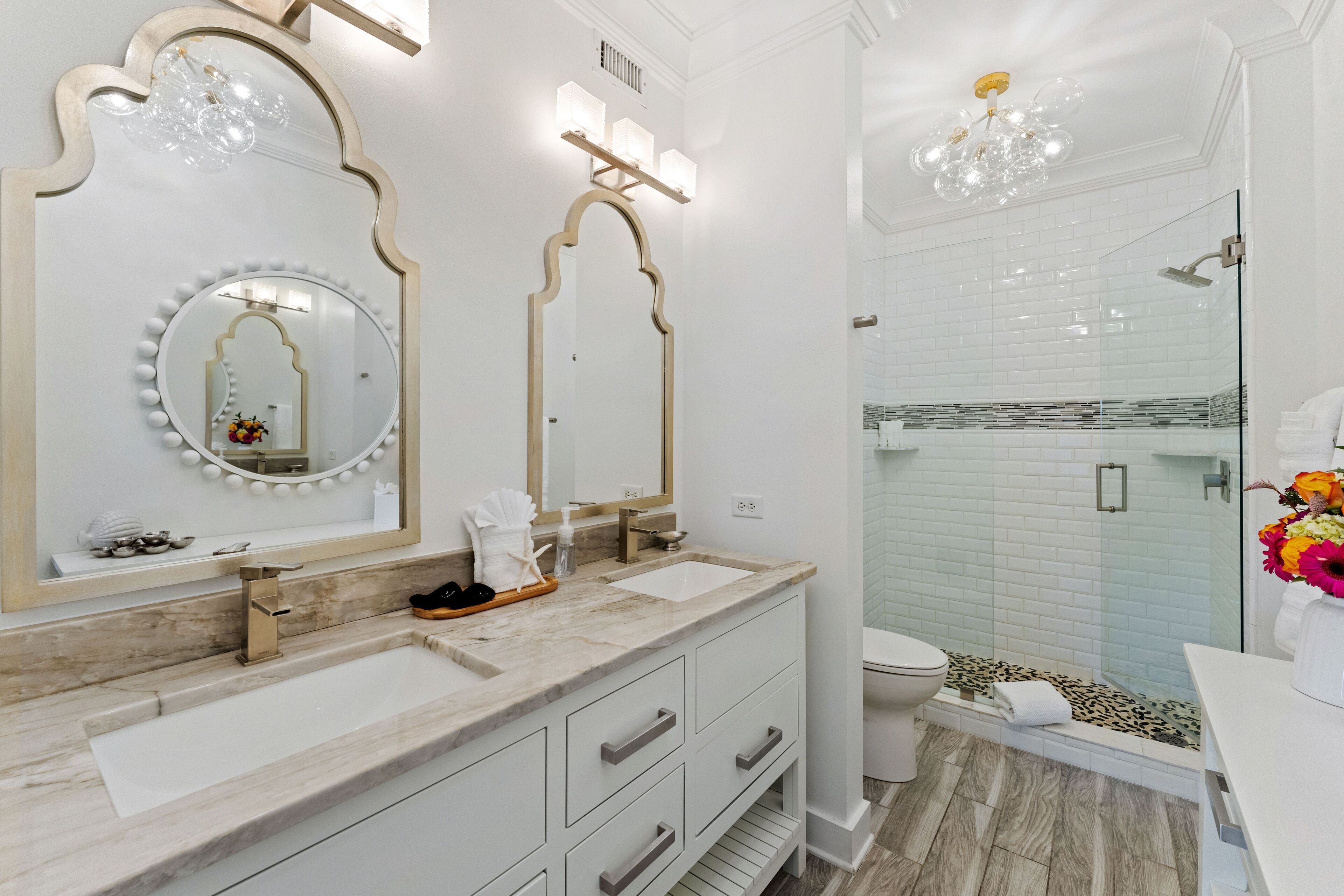 Een moderne badkamer met twee wasbakken, een grote spiegel en een douche.