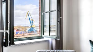A room with a large window overlooking a construction site with cranes.