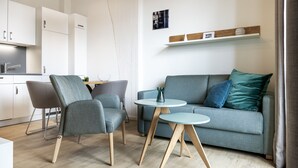 A modern living room with a grey sofa, two armchairs, and a small round table.