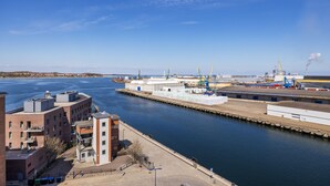 Zona industrial frente al agua con edificios, un muelle y grúas.