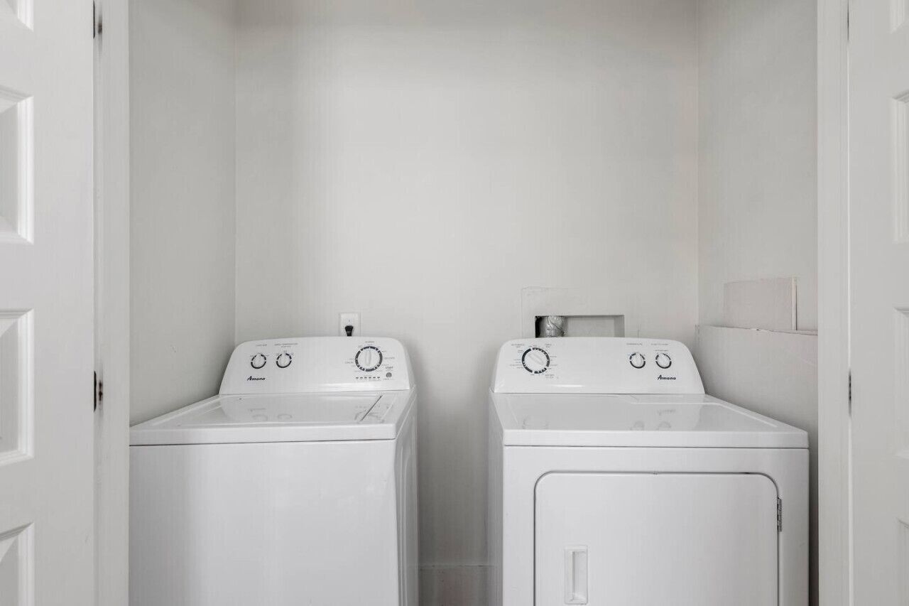 Une buanderie équipée de deux machines à laver à chargement frontal.