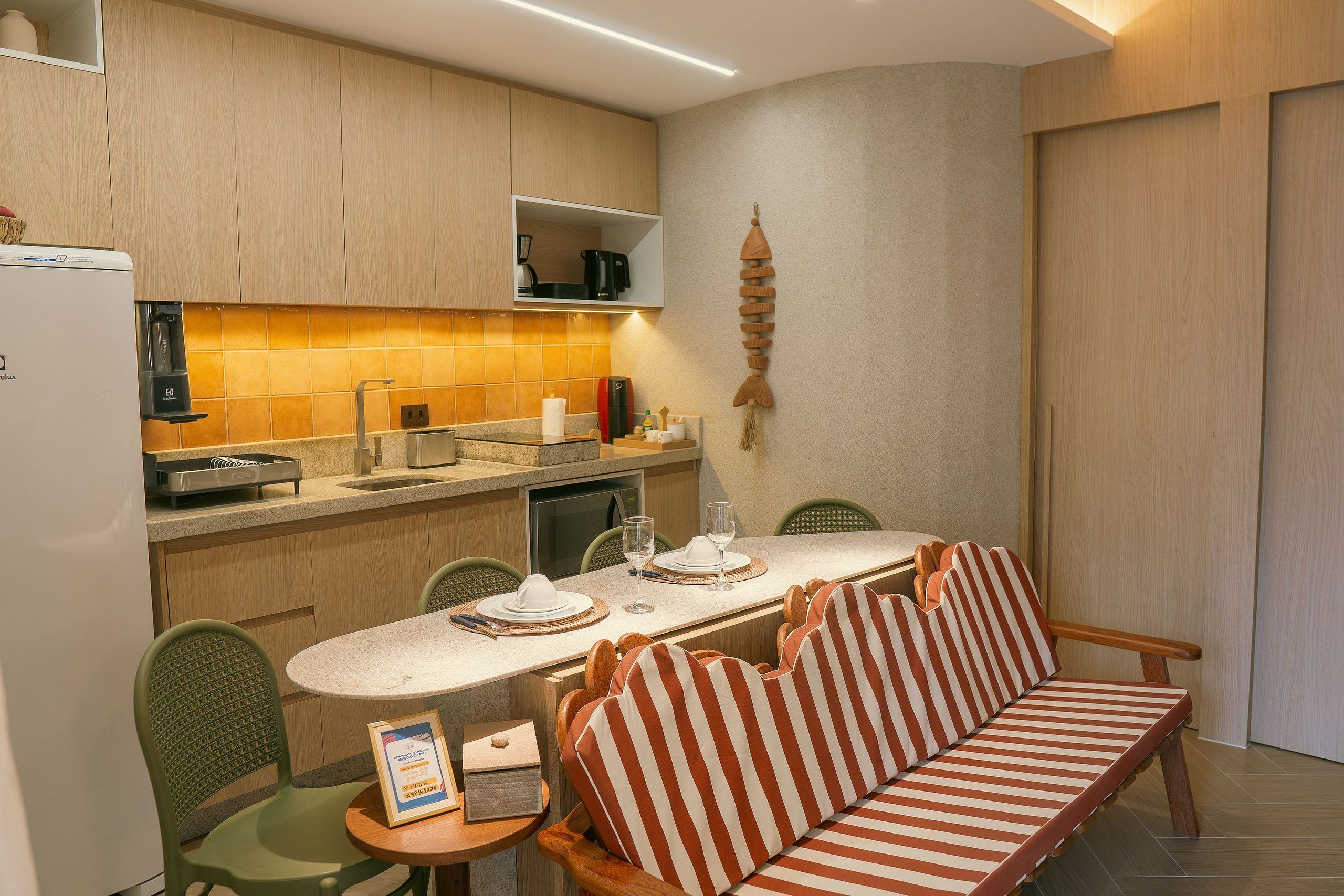 A compact kitchen with a dining area, including a sofa and chairs.