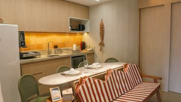 A compact kitchen with a dining area, including a sofa and chairs.