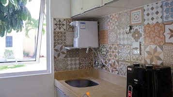 A kitchen with a built-in water dispenser, a sink, and patterned tiles.