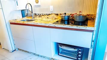 Una cocina con fregadero, estufa y horno.