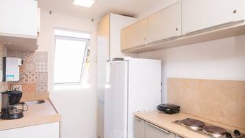 Comfort appartement | Privékeuken | Een koelkast, een magnetron, kookgerei, borden en bestek