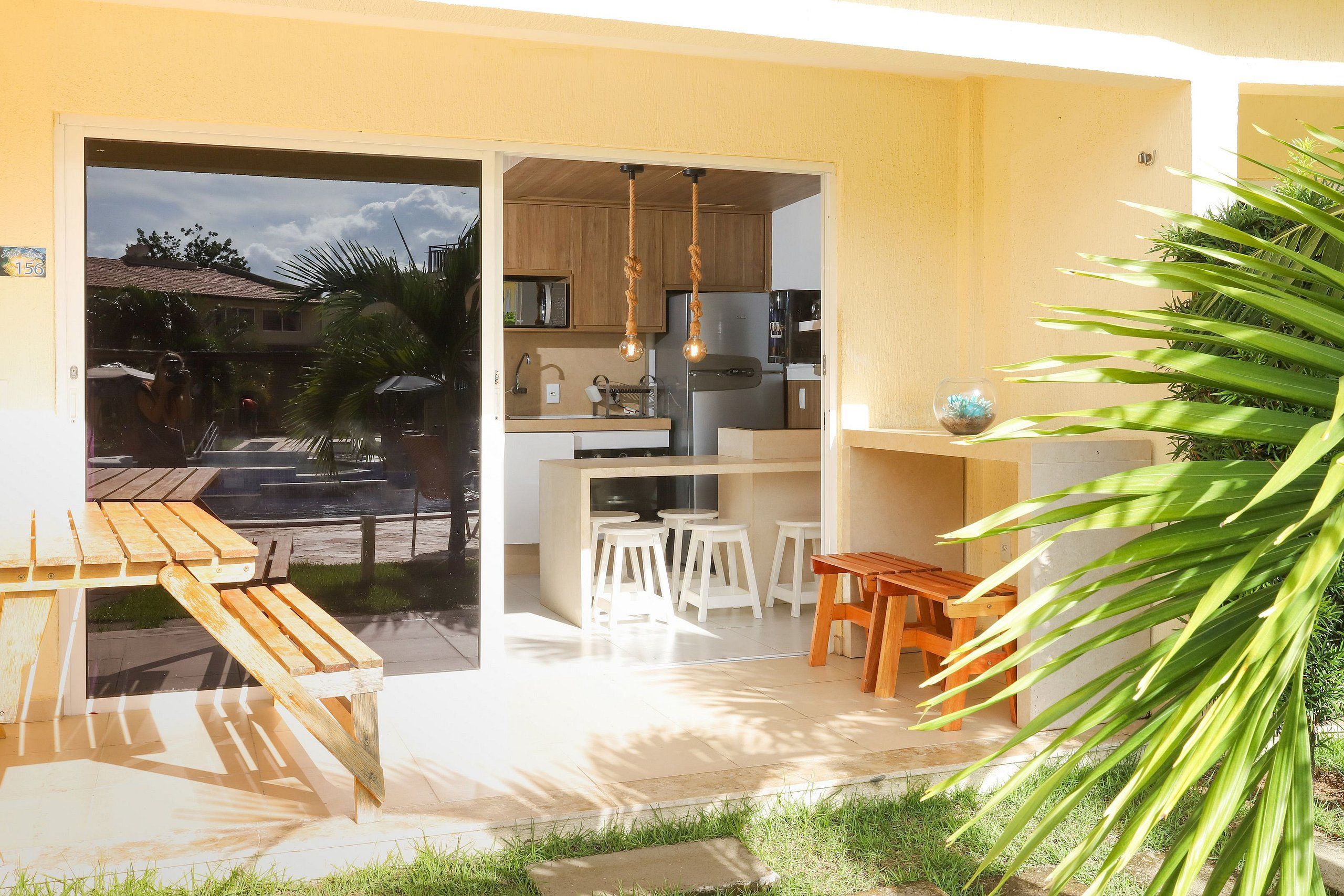 Cucina open space con zona pranzo, arredi in legno e vista sul quartiere.