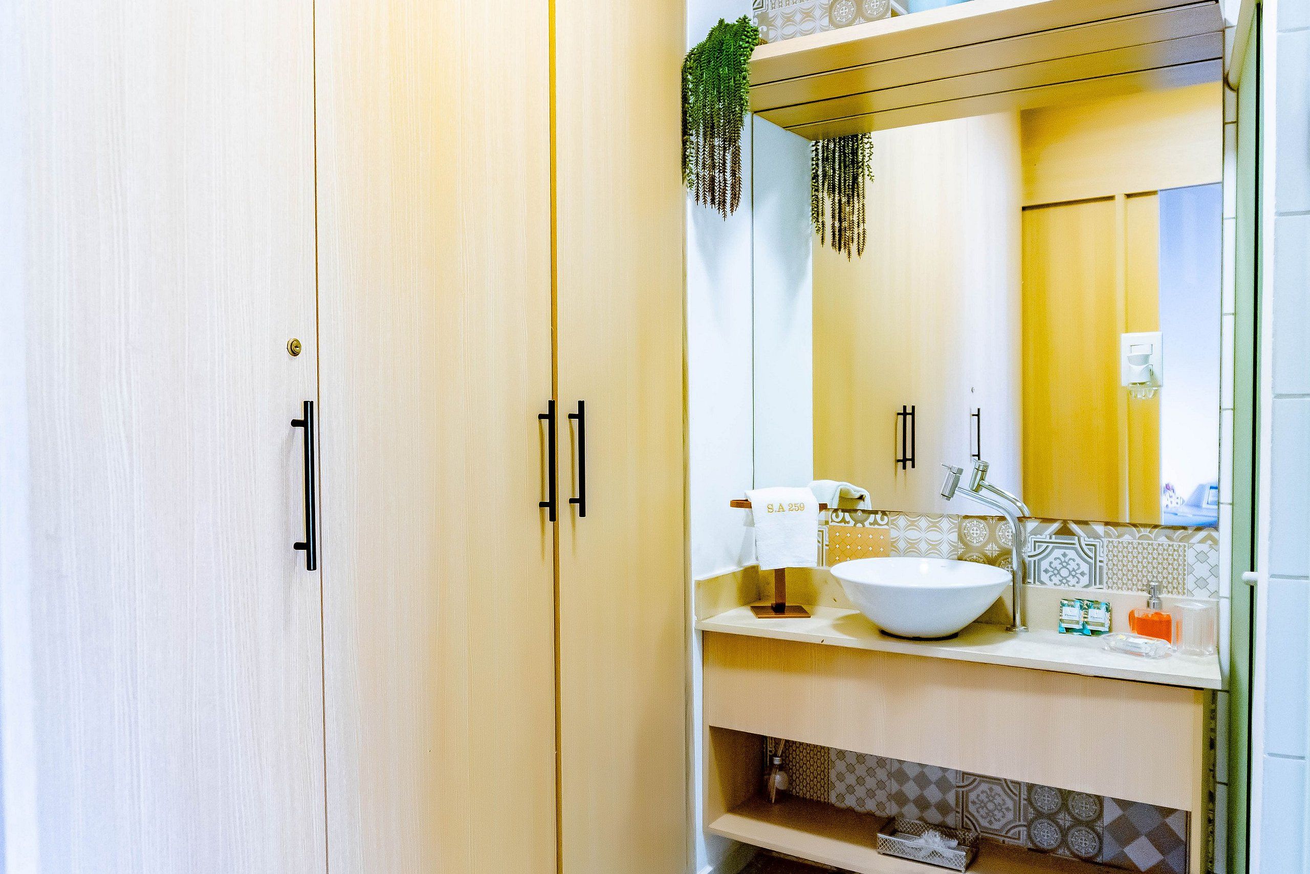A bathroom with a white sink, a mirror, and a towel rack.