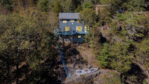 Une maison à l’extérieur bleu, dotée d’un balcon et d’un escalier menant à l’entrée.