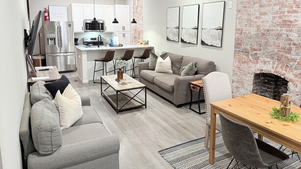 Una sala de estar moderna con un sofá gris, una mesa de centro de madera y una chimenea.
