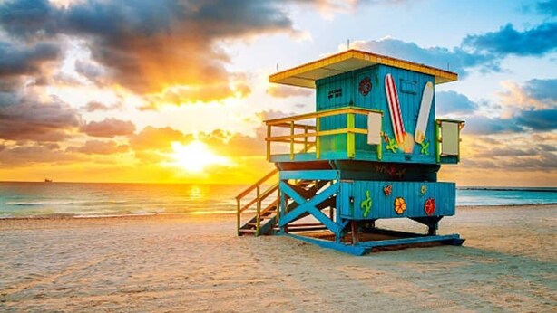 A lifeguard tower on a beach with a sunset in the background. - SOUTH BEACH, SOFI, Minutes From Beach! (Miami Beach)