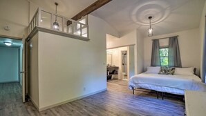 Una camera da letto con un letto, una scala e un bagno visibile sullo sfondo.