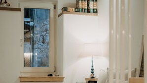 Makuuhuoneessa on sänky, yöpöytä, lamppu, ikkuna ja hylly, jossa on kirjoja.